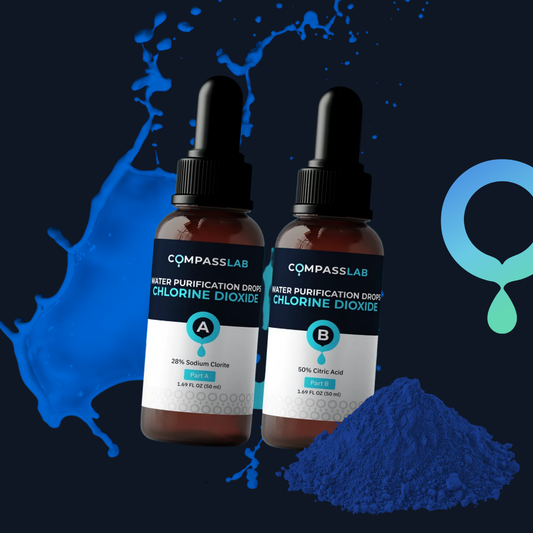 Two CompassLab water purification dropper bottles labeled Chlorine Dioxide, shown against a dark blue background with blue splash graphics and a pile of blue powder. The bottles are labeled A and B with different chlorine dioxide concentrations.